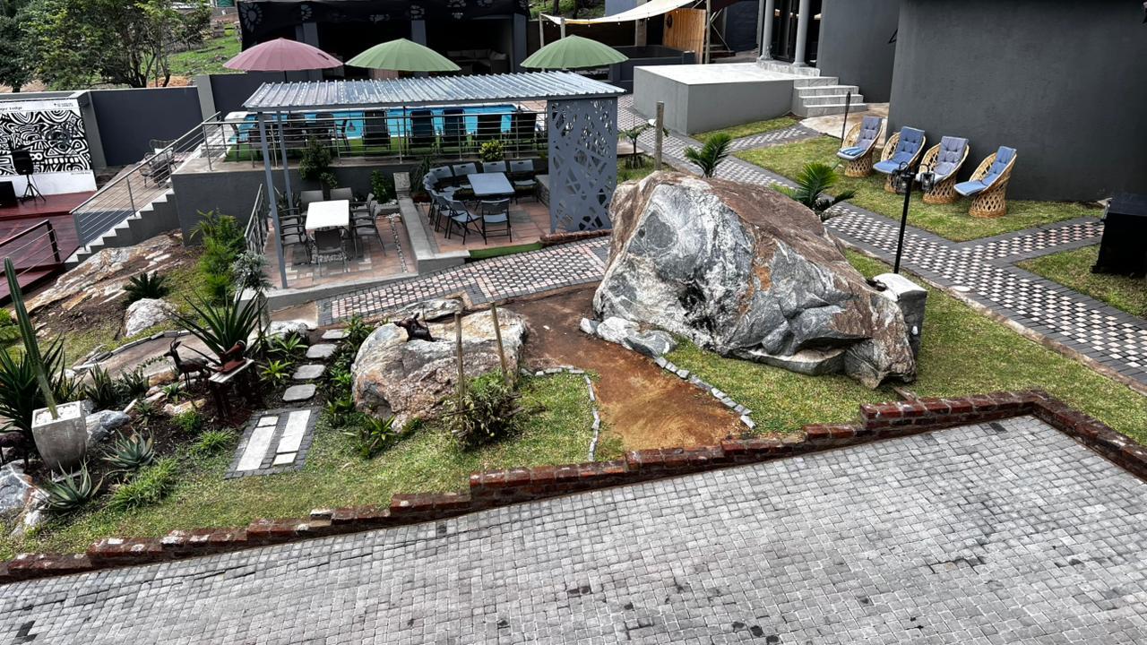 Landscaped lodge grounds with granite boulders, aloes and paved walkways