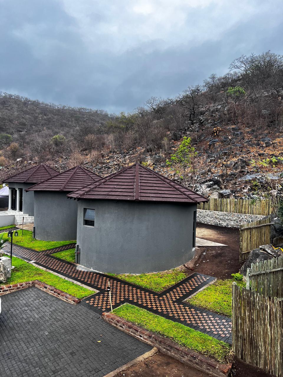 Round chalets with tiled roofs set against the rocky Mpumalanga hillside